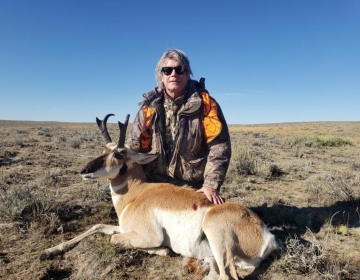 Hunter posing in his orange camo vest with his antelope